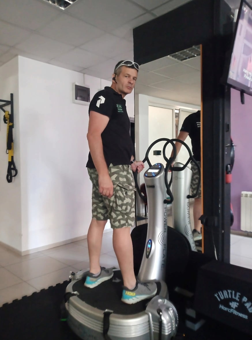 Vladimir in the gym posing on the vibration plate